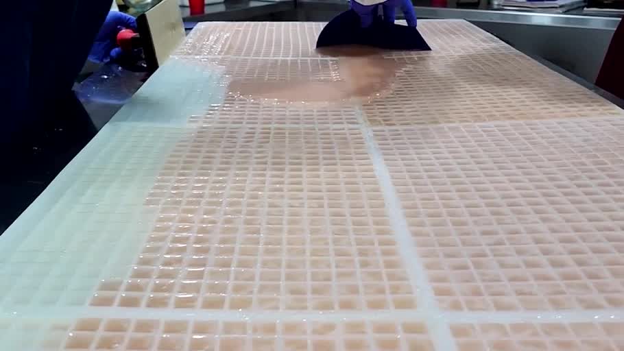 Large reusable commercial silicone gummy molds filled during a real starchless gummy production run