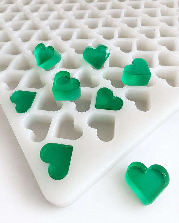 Close-up of 2.76mL heart silicone gummy mold with emerald green heart gummies