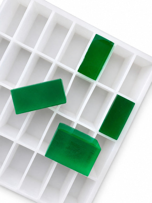 Angled view of a 20mL rectangle gummy mold with 119 cavities and translucent emerald green rectangular gummies