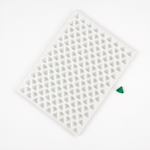 Angled view of a 2mL diamond gummy mold with 179 cavities and an emerald green gummy on a white background