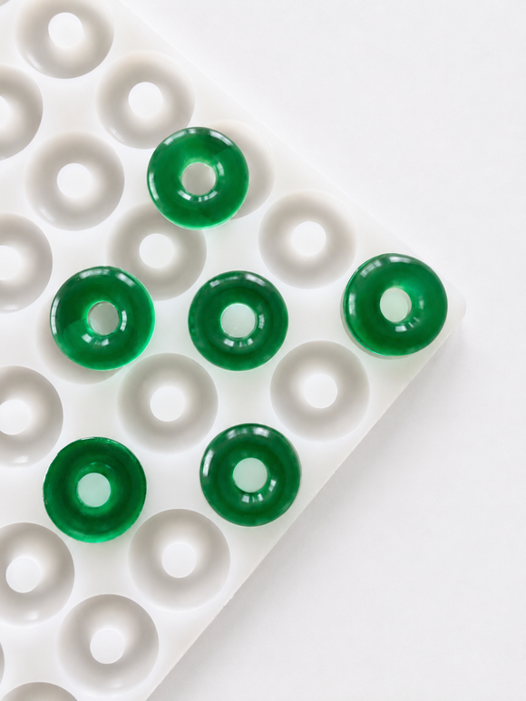 Moule à gummies anneau pêche de 3.4 mL - 108 cavites - vue en angle, avec des gummies vert émeraude, translucides