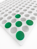 Angled view of 3.8mL 130-cavity coin silicone gummy mold with green gummies