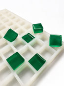 Moule à gummies carrés de 6 mL, 165 cavités — vue latérale en angle; gummies carrés translucides vert émeraude; fond blanc