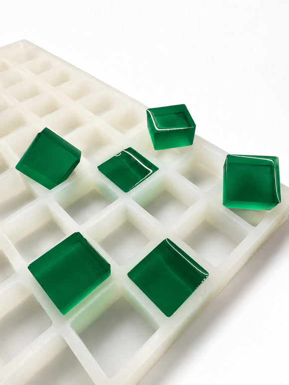 Moule à gummies carrés de 6 mL, 165 cavités — vue latérale en angle; gummies carrés translucides vert émeraude; fond blanc